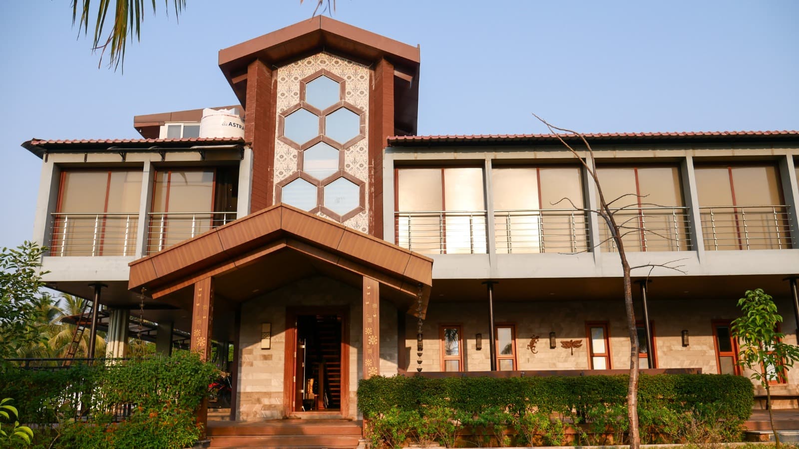 Farmhouse entrance with a hexagonal glass feature wall, built by Lands & Riches